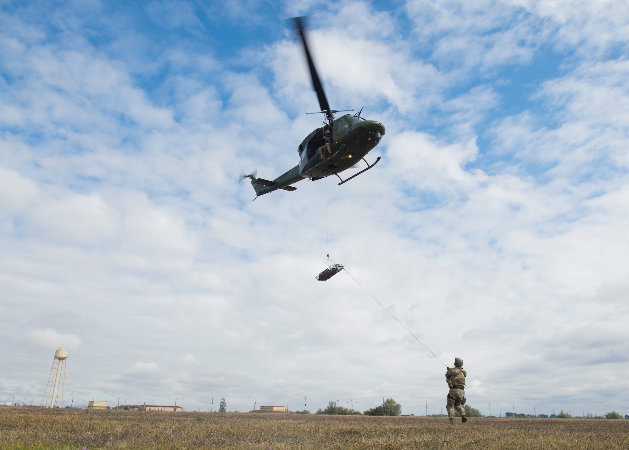 U.S. Air Force Tech. Sgt. James Pennington, 336th Training Group independent medical technician, and members from the 36th Rescue Squadron perform a rescue demonstration prior to the commemoration ceremony of the 36th RQS reaching 700 saves at Fairchild Air Force Base, Washington, Sept. 20, 2019. The 36th RQS is the only operational rescue squadron flying UH-1N helicopters within the United States that is qualified to perform 24-hour medical evacuation alert, water rescue, cargo sling and hoist operations. (U.S. Air Force photo by Airman 1st Class Lawrence Sena)