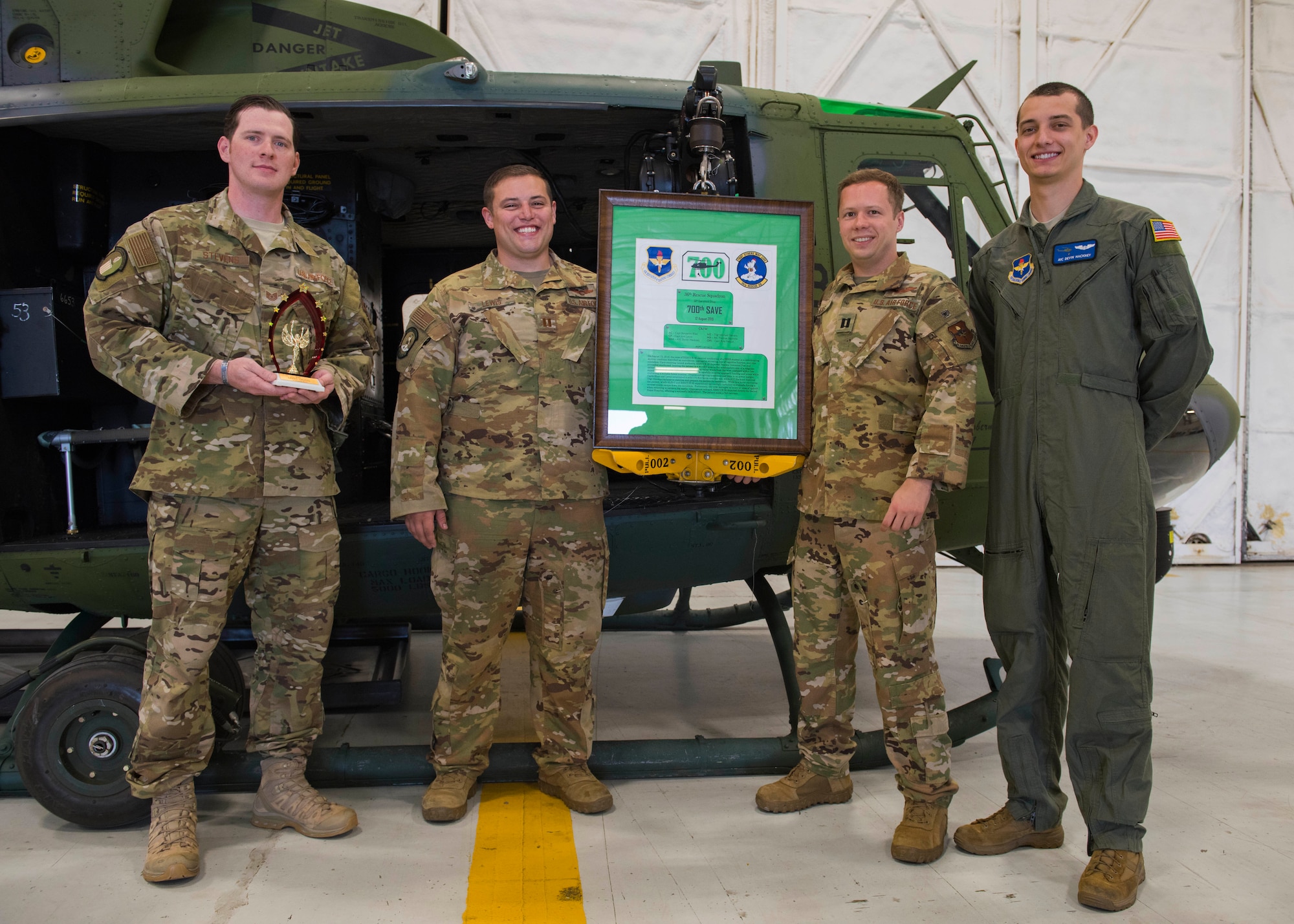 U.S. Air Force air crew members from the 36th Rescue Squadron unveil a plaque during a ceremony commemorating the squadron reaching 700 saves at Fairchild Air Force Base, Washington, Sept. 20, 2019. Events during the ceremony included a UH-1N helicopter medical evacuation demonstration, helicopter fly-over and unveiling of the plaque commemorating the 700th save that took place Aug. 12, 2019. (U.S. Air Force photo by Airman 1st Class Lawrence Sena)