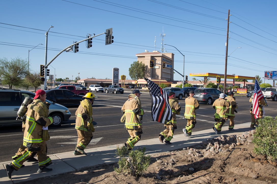 U.S. Marines with Aircraft Rescue and Firefighting (ARFF), Headquarters and Headquarters Squadron (H&HS), Marine Corps Air Station (MCAS) Yuma participate in Yuma's local 9/11 Moving Tribute 5K in Yuma, Ariz., Sept. 11, 2019. MCAS Yuma's ARFF ran alongside local fire departments, and civilians, remembering and honoring the victims of 9/11. The 5K began at City of Yuma Fire Station #3 and finished at City of Yuma Fire Station #1. (U.S. Marine Corps photo by Sgt. Allison Lotz)