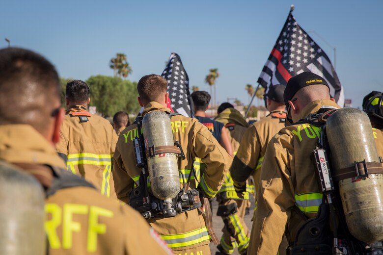 U.S. Marines with Aircraft Rescue and Firefighting (ARFF), Headquarters and Headquarters Squadron (H&HS), Marine Corps Air Station (MCAS) Yuma participate in Yuma's local 9/11 Moving Tribute 5K in Yuma, Ariz., Sept. 11, 2019. MCAS Yuma's ARFF ran alongside local fire departments, and civilians, remembering and honoring the victims of 9/11. The 5K began at City of Yuma Fire Station #3 and finished at City of Yuma Fire Station #1. (U.S. Marine Corps photo by Sgt. Allison Lotz)