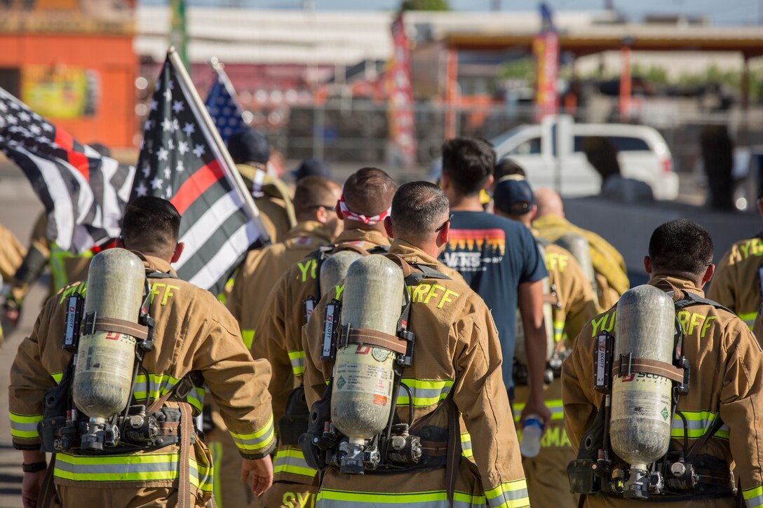 U.S. Marines with Aircraft Rescue and Firefighting (ARFF), Headquarters and Headquarters Squadron (H&HS), Marine Corps Air Station (MCAS) Yuma participate in Yuma's local 9/11 Moving Tribute 5K in Yuma, Ariz., Sept. 11, 2019. MCAS Yuma's ARFF ran alongside local fire departments, and civilians, remembering and honoring the victims of 9/11. The 5K began at City of Yuma Fire Station #3 and finished at City of Yuma Fire Station #1. (U.S. Marine Corps photo by Sgt. Allison Lotz)