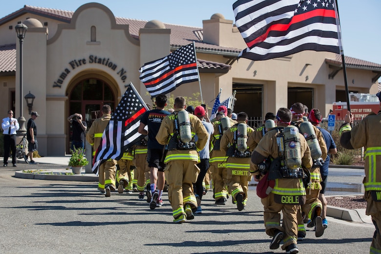 U.S. Marines with Aircraft Rescue and Firefighting (ARFF), Headquarters and Headquarters Squadron (H&HS), Marine Corps Air Station (MCAS) Yuma participate in Yuma's local 9/11 Moving Tribute 5K in Yuma, Ariz., Sept. 11, 2019. MCAS Yuma's ARFF ran alongside local fire departments, and civilians, remembering and honoring the victims of 9/11. The 5K began at City of Yuma Fire Station #3 and finished at City of Yuma Fire Station #1. (U.S. Marine Corps photo by Sgt. Allison Lotz)