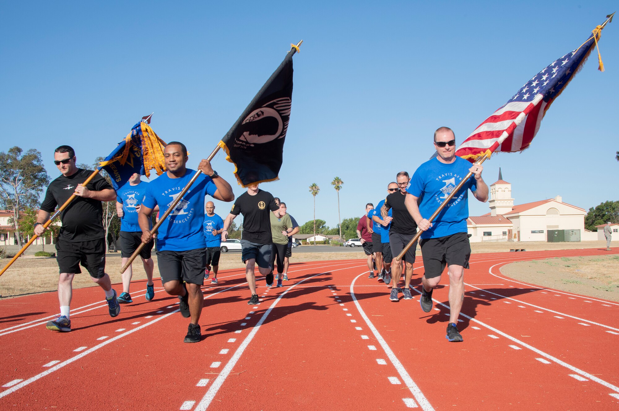 First sergeants from Travis Air Force Base run on the fitness center track with the U.S. and POW/MIA flags, Sept. 19, 2019, at Travis Air Force Base, California. Service members, civilians and family members kept the flags in constant motion for a 24-hour period. According to the Defense POW/MIA Accounting Agency, more than 82,000 Americans remain missing from WWII, Korean War, Vietnam War, Cold War, Gulf Wars and other conflicts. The names of service members still unaccounted for were recited throughout the run. (U.S. Air Force photo by Heide Couch)