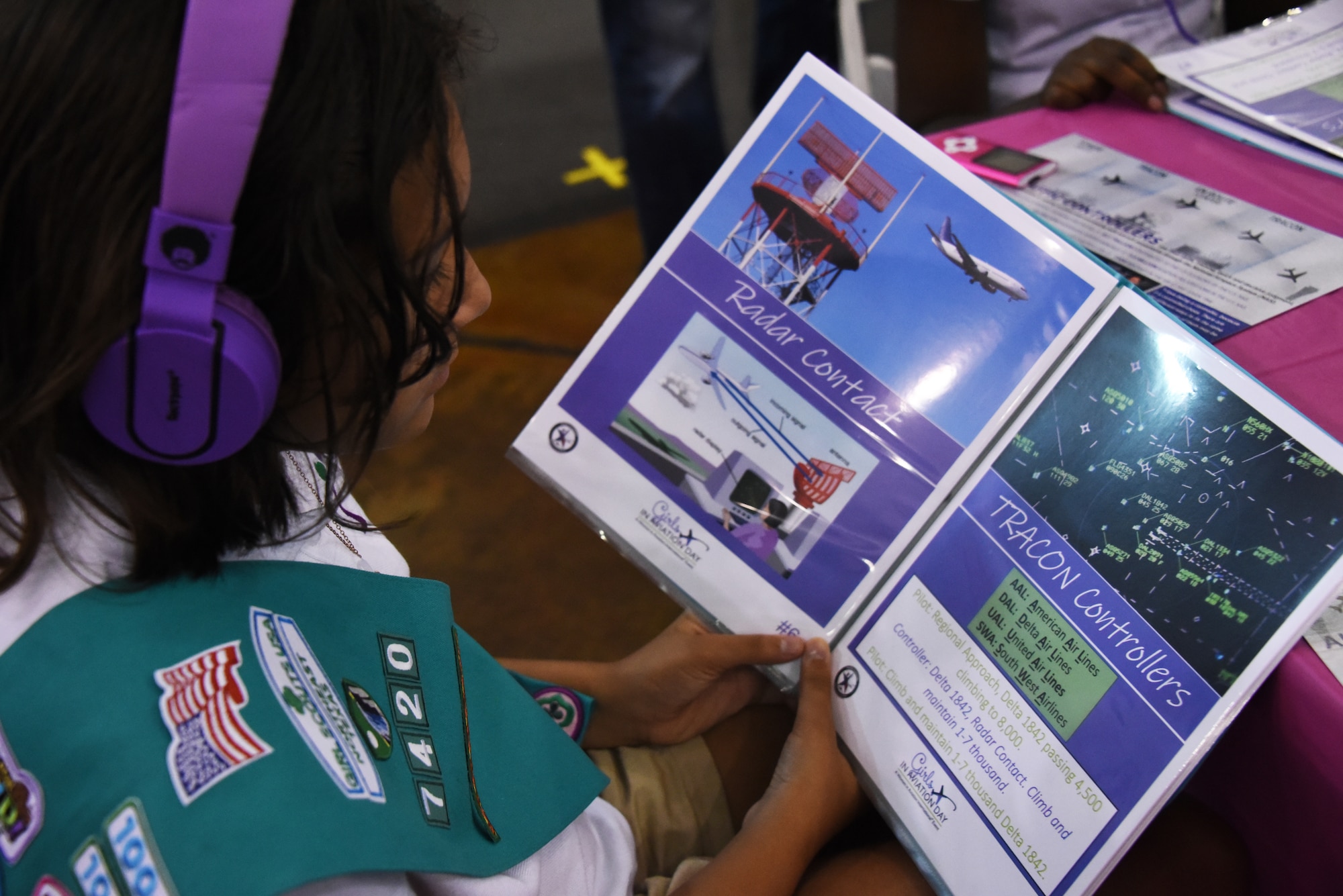 A girl scout studies a book of air traffic phraseology during the Girls in Aviation Day