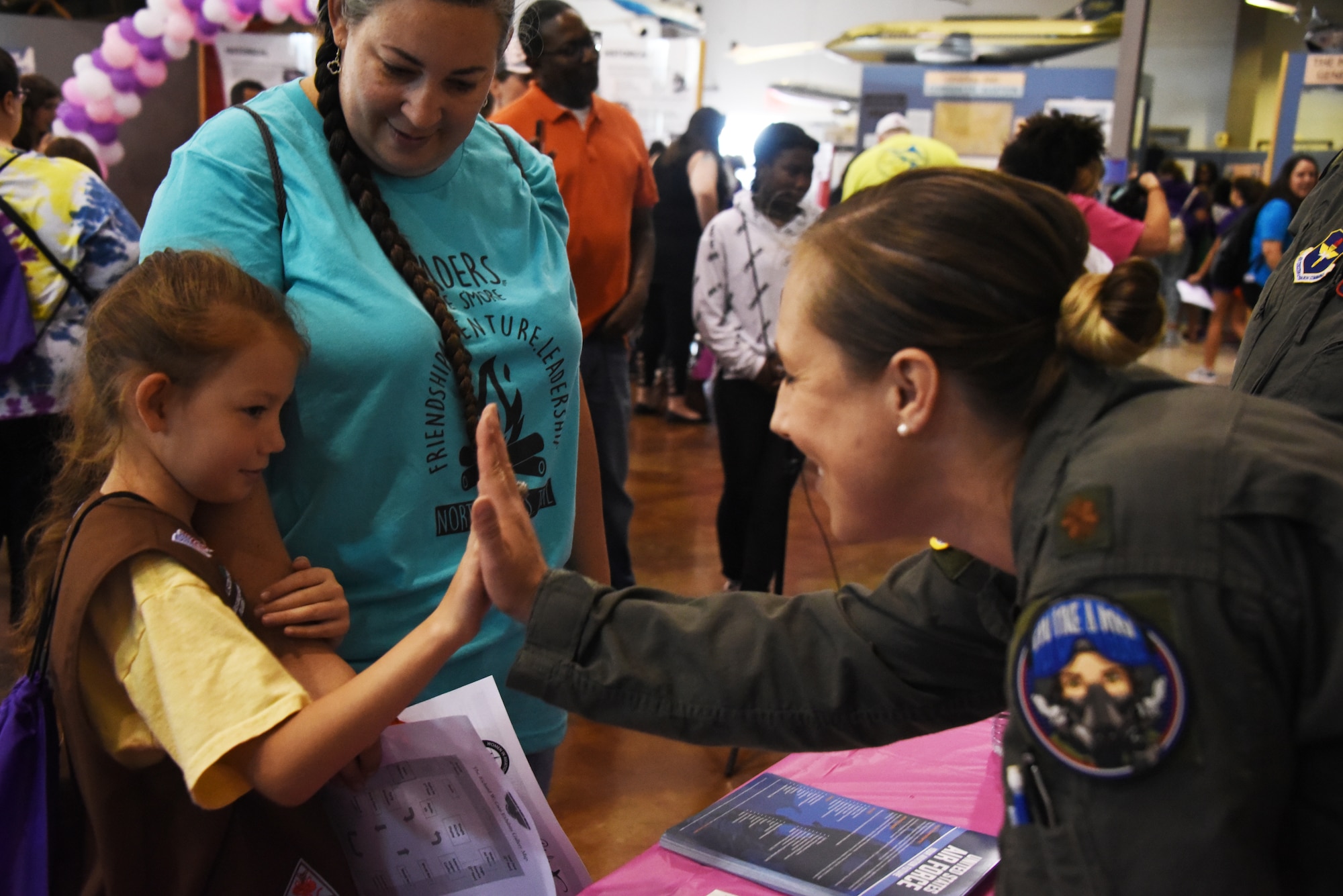 An Air Education and Training Command Women’s Fly-In Event participant high-fives a young woman during the Girls in Aviation Day