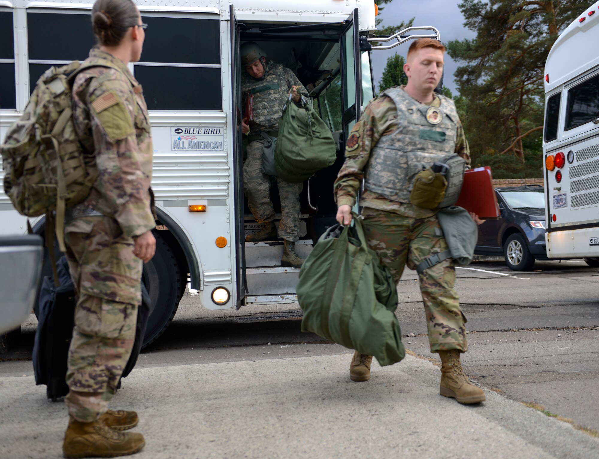 U.S. Airmen unload from a bus at Ramstein Air Base, Germany, Sept. 23, 2019. As simulated deployers for Operation Varsity 19-3, the Airmen processed the personnel deployment function line before being transported to a temporary lodging facility. (U.S. Air Force photo by Tech. Sgt. Timothy Moore)