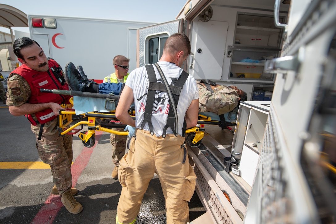 380th Air Expeditionary Wing firefighters and medics move a moulage victim into an ambulance during a large first responder exercise Sept. 24, 2019, at Al Dhafra Air Base, United Arab Emirates. A variety of agencies including medics, firefighters and security forces defenders participated in the exercise to test their readiness, knowledge of emergency procedures and interagency cooperation amongst the wing’s first responders. (U.S. Air Force photo by Staff Sgt. Chris Thornbury)