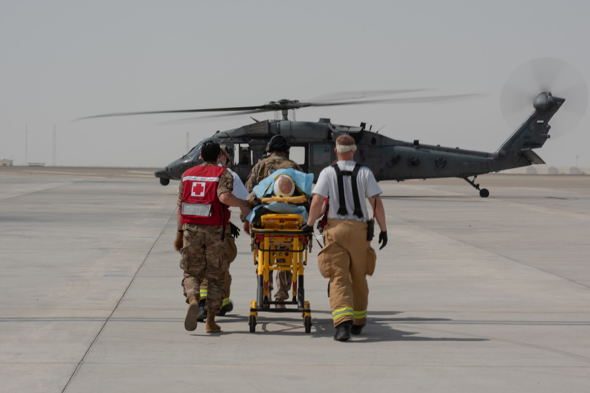 380th Air Expeditionary Wing firefighters and medics move a simulated patient to an Emirati UH-60 Black Hawk during a large first responder exercise Sept. 24, 2019, at Al Dhafra Air Base, United Arab Emirates. The exercise helped foster partnership with the United Arab Emirates Air Force Joint Aviation Command to practice an aeromedical evacuation scenario via helicopter. (U.S. Air Force photo by Staff Sgt. Chris Thornbury)