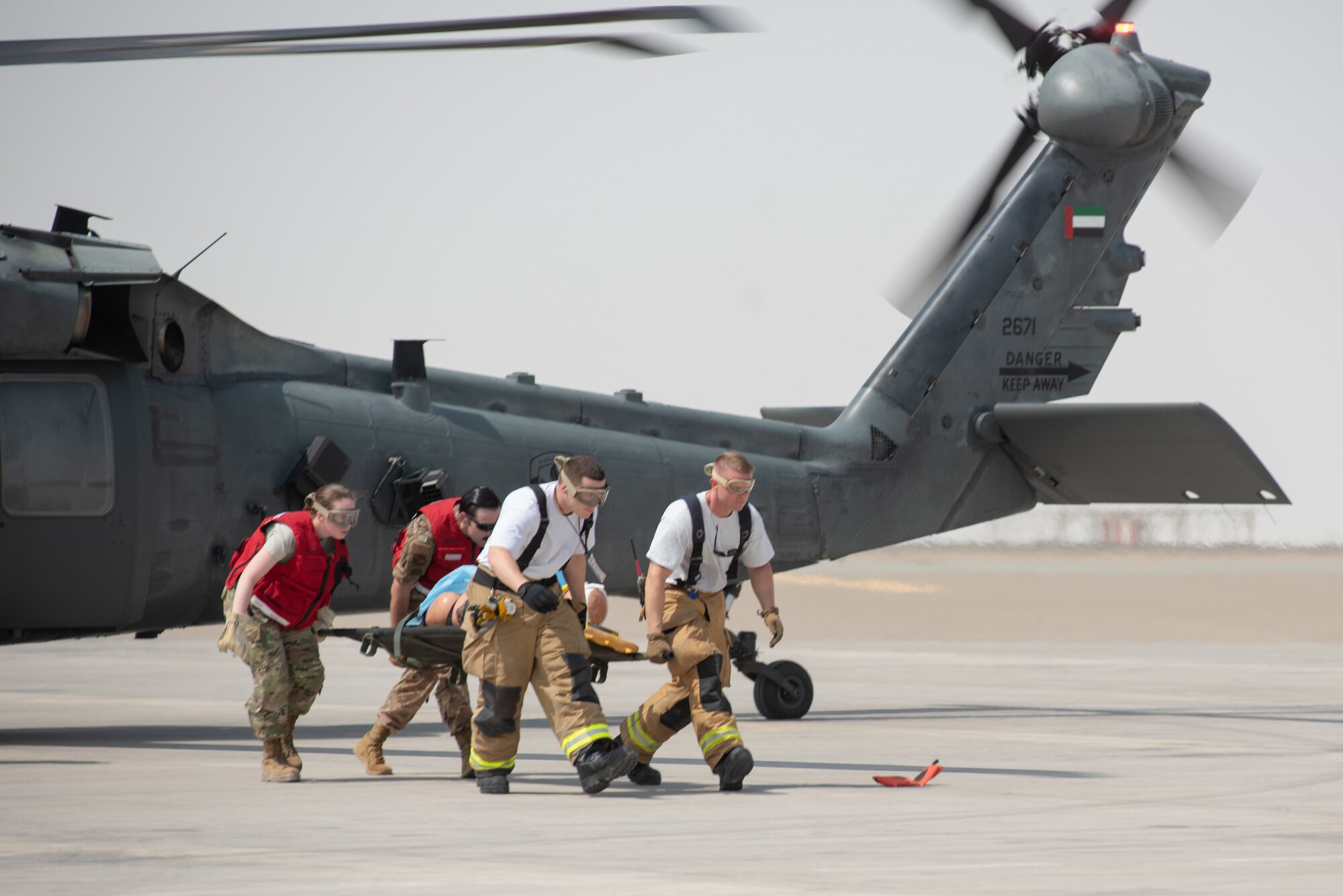 380th Air Expeditionary Wing firefighters and medics remove a simulated patient from an Emirati UH-60 Black Hawk during a large first responder exercise Sept. 24, 2019, at Al Dhafra Air Base, United Arab Emirates. The exercise helped foster partnership with the United Arab Emirates Air Force Joint Aviation Command to practice an aeromedical evacuation scenario via helicopter. (U.S. Air Force photo by Staff Sgt. Chris Thornbury)