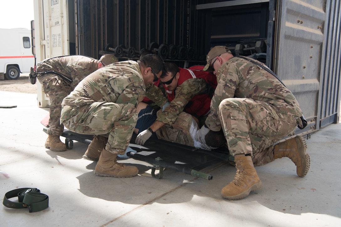 First responders work together to roll a simulated casualty onto a litter during a first responder exercise Sept. 24, 2019, on Al Dhafra Air Base, United Arab Emirates. A variety of agencies including medics, firefighters and security forces defenders participated in the exercise to test their readiness, knowledge of emergency procedures and interagency cooperation amongst the wing’s first responders. (U.S. Air Force photo by Tech. Sgt. Jocelyn A. Ford)