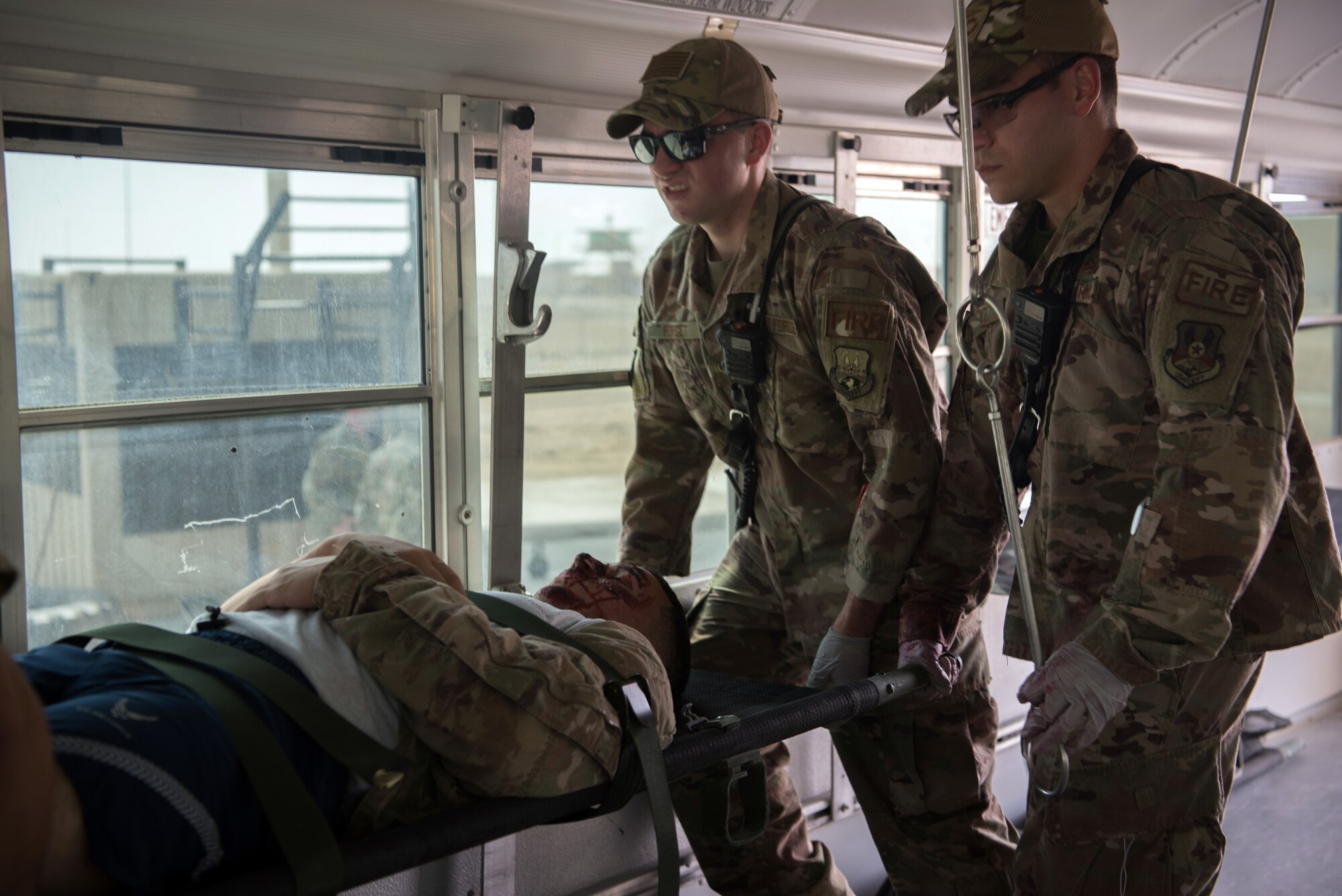 Firefighters assigned to the 380th Expeditionary Civil Engineer Squadron load a simulated casualty onto a medical transportation bus during a first responder exercise Sept. 24, 2019, on Al Dhafra Air Base, United Arab Emirates. The exercise showcased the readiness, knowledge of emergency procedures and interagency cooperation amongst the wing’s first responders. (U.S. Air Force photo by Tech. Sgt. Jocelyn A. Ford)