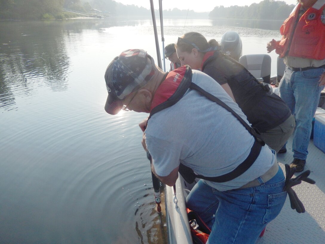 U.S. Army Corps of Engineers, Savannah District Driller Matt Cook (foreground) and Geologist April Kelly use specialty equipment to collect a soil sample from the bottom of the river behind the Augusta Training Wall. The samples are being collected as part of a disposition study to determine the cost and benefit of removing the old under-water training wall from the Savannah River.  USACE photo by Justin Nixon