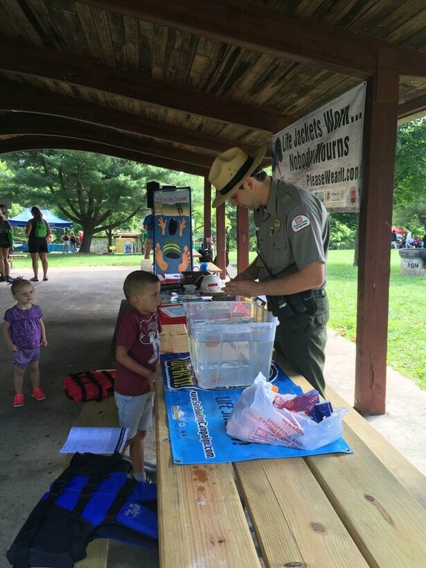 A Blue Marsh Lake Park Ranger speaks with a child about Water Safety at an exhibit table.