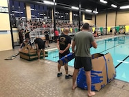 Battalion command teams prepare to launch their boats in the pool for the "Boat Wars" competition at Gammon Physical Fitness Center, Fort Knox, Kentucky, Sept. 22. The "Boat War" was a team building exercise that leadership teams participated in during the 3rd Recruiting Brigade's three-day training forum.
