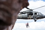 A Colorado Army National Guard helicopter crew lowers a member of Mountain Rescue Aspen down to an injured hiker near the North Maroon Bells Peak near Aspen, Colorado, July 24, 2018. The COARNG and the Colorado Hoist Rescue Team incorporate civilian alpine rescue personnel and military hoist helicopter capabilities to improve Colorado search and rescue systems, operations and training. (Photo courtesy Tyler McCready, used with permission)