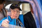 George Hamm, a WWII veteran who served with the 30th Infantry Division,  holds a flag out a window during a parade through Maastricht in the Limburg Province of the Netherlands tSept. 14, 2019, in celebration of the 75th anniversary of the liberation by 30th Infantry Division Soldiers in September 1944. North Carolina National Guard Soldiers escorted the veterans, with whom they share a unit lineage, riding in classic cars and WWII era military vehicles through the streets lined with thousands of people.