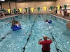 2 canoes sinking in pool and 1 man in red shirt standing in pool
Leadership teams racing to the finish line in the Boat Wars competition.