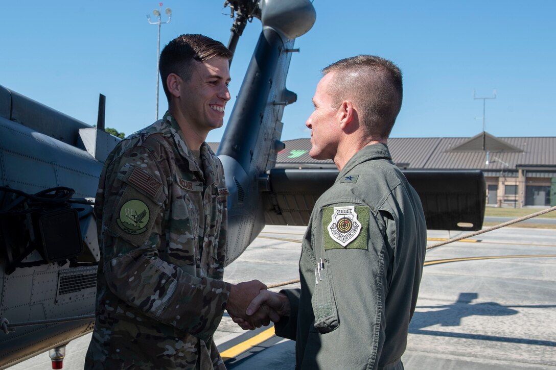 U.S. Air Force Brig. Gen. Kenneth Ekman, right, 1st Air Force and Air Forces Northern Command vice commander, coins Senior Airman Matthew Sinclair, 41st Rescue Squadron intelligence analyst, Sept. 23, 2019, at Moody Air Force Base, Ga. Ekman recognized Airmen assigned to the 347th Rescue Group and support personnel from across the installation for their assistance with foreign disaster relief efforts in the wake of Hurricane Dorian. (U.S. Air Force photo by Airman Azaria E. Foster)