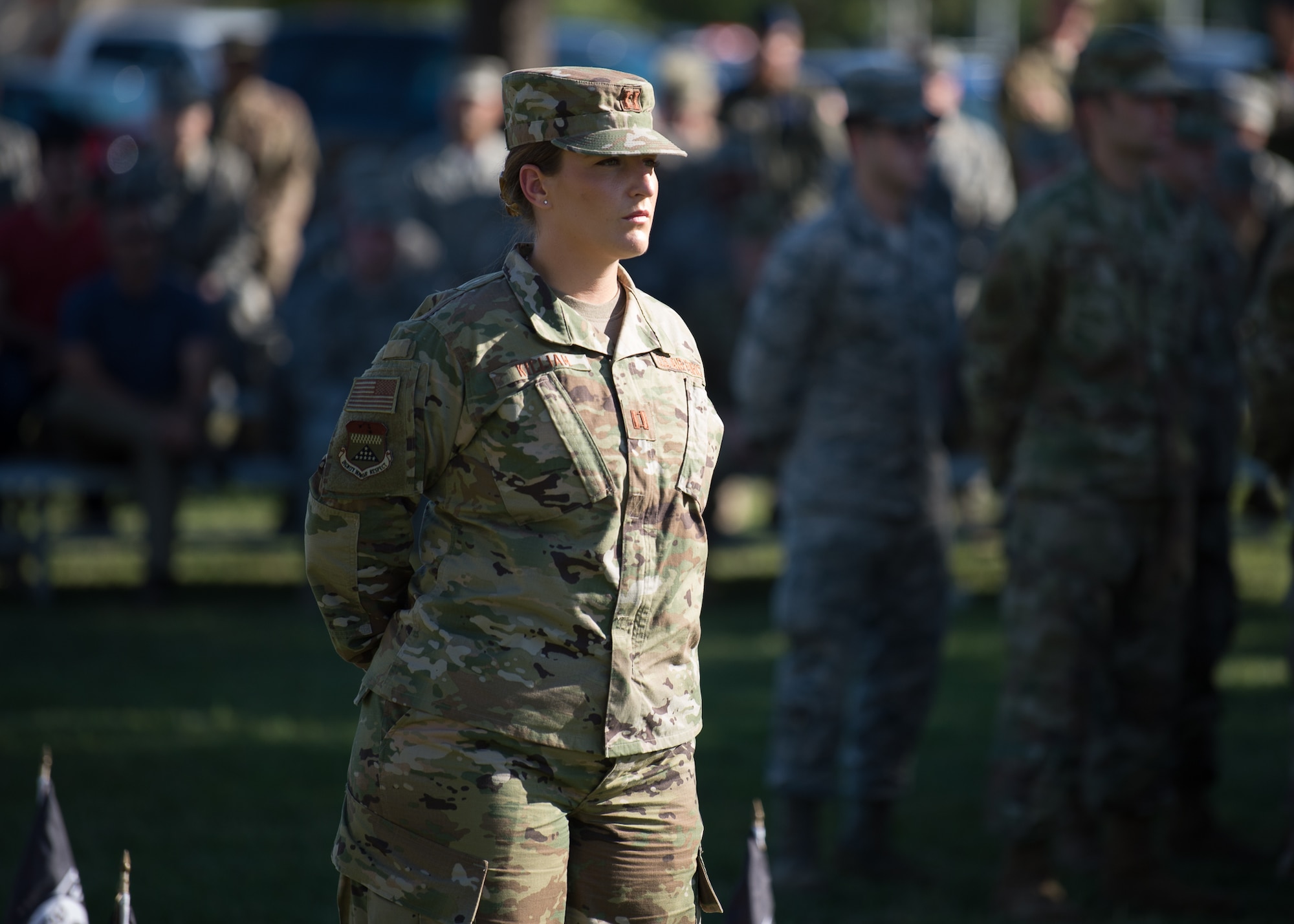 Capt. Courtney Killian, Air Force Mortuary Affairs Operations dignified transfer officer in charge, stands at parade rest during a retreat ceremony commemorating National POW/MIA Recognition Day Sept. 20, 2019, at Dover Air Force Base, Del.  Behind Killian was a formation of POW/MIA flags representing more than 82,000 U.S. military service members still missing in action. (U.S. Air Force photo by Mauricio Campino)