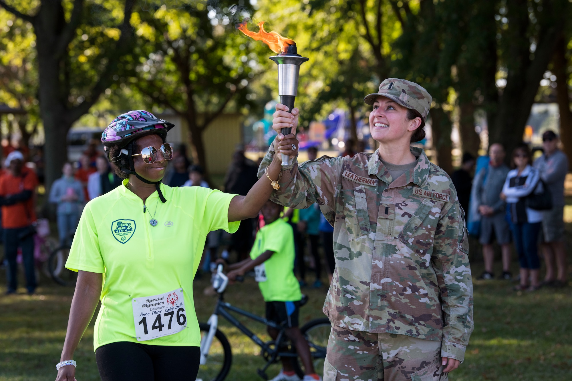 (Right) 1st Lt. Jamie Leatherman, 436th Aircraft Maintenance Squadron, holds the torch with contestant Anne Marie Eaddie-Smith during the Special Olympics Delaware 2019 cycling tournament Sept. 21, 2019, at Dover Air Force Base, Del. More than 100 volunteers came together to help make this event possible. (U.S. Air Force photo by Senior Airman Christopher Quail)
