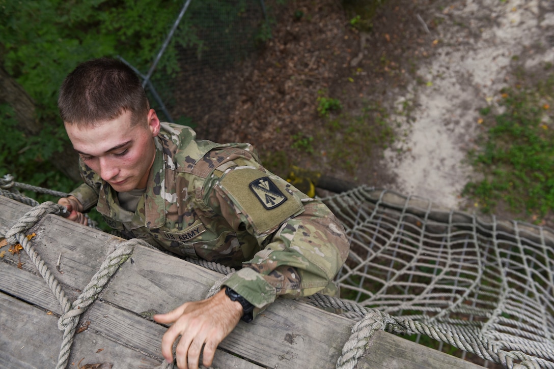 U.S. Army Pvt. Benjamin Sheppard, Charlie Company, 222nd Battalion, 1st Aviation Regiment, 128th Aviation Brigade UH-60 Black Hawk helicopter advanced individual training student, climbs a cargo net during a field training exercise at Joint Base Langley-Eustis, Virginia, Sept. 18, 2019.