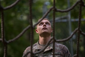 U.S. Army Pvt. Jeffrey Lawless, Charlie Company, 222nd Battalion, 1st Aviation Regiment, 128th Aviation Brigade UH-60 Black Hawk helicopter advanced individual training student, looks up at a cargo net during a field training exercise at Joint Base Langley-Eustis, Virginia, Sept. 18, 2019.
