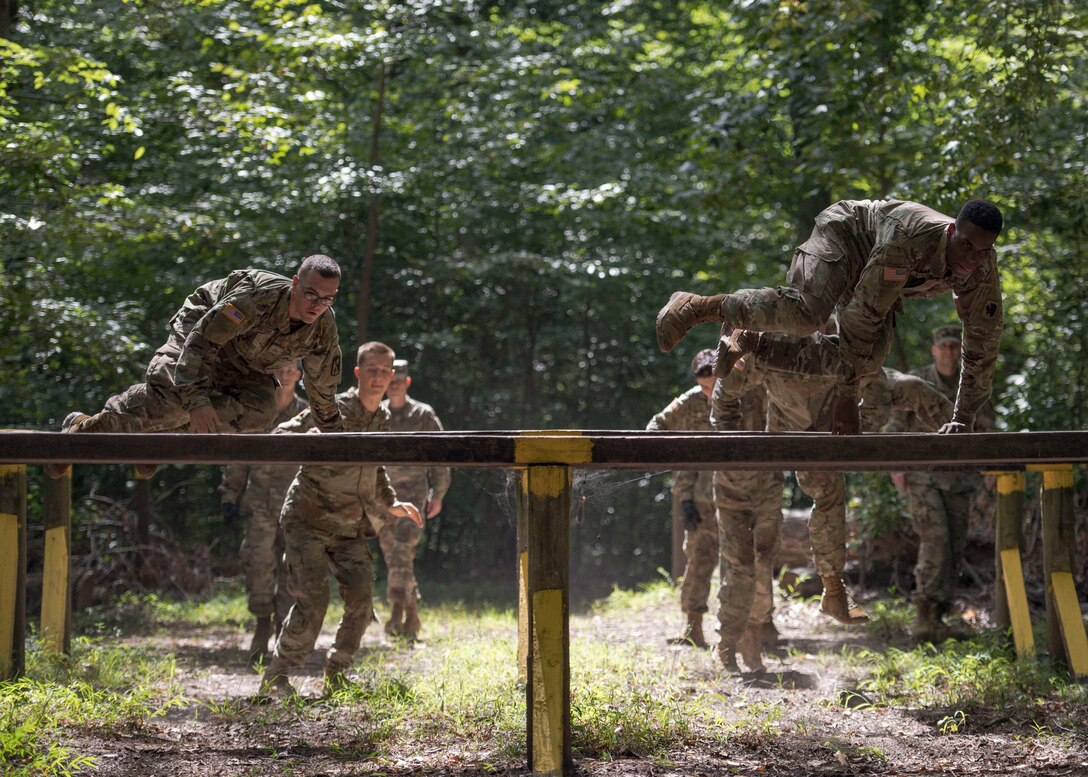 U.S. Army initial entry training Soldiers jump over hurdles during a field training exercise at Joint Base Langley-Eustis, Virginia, Sept. 18, 2019.