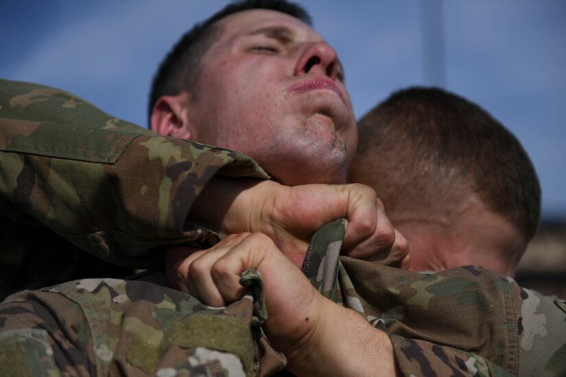 U.S. Army Pvt. Tyler Gates applies a combative technique on Pvt. Gideon Ellison, both assigned to Charlie Company, 222nd Battalion, 1st Aviation Regiment, 128th Aviation Brigade UH-60 Black Hawk helicopter advanced individual training students, during a field training exercise at Joint Base Langley-Eustis, Virginia, Sept. 20, 2019.