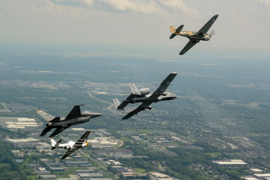 A P-40 Warhawk and P-51 Mustang fly alongside a U.S. Air Force F-16C Fighting Falcon and A-10C Thunderbolt II during a formation flight over Indianapolis, Ind., May 25, 2019. The formation, known as Heritage Flight, flew over the 103rd running of the Indianapolis 500. (U.S. Air Force photo by Staff Sgt. Betty R. Chevalier)