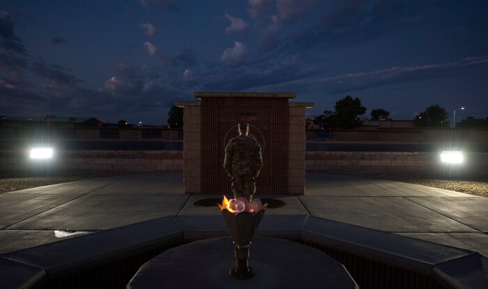 An Airman stands at attention in front of the POW/MIA Memorial at Heritage Park on Holloman Air Force Base, N.M., Sept. 20, 2019. During the 24-hour vigil, Airmen took turns standing at the memorial, honoring service members who were imprisoned and remain missing-in-action. (U.S. Air Force photo by Staff Sgt. Christine Groening)