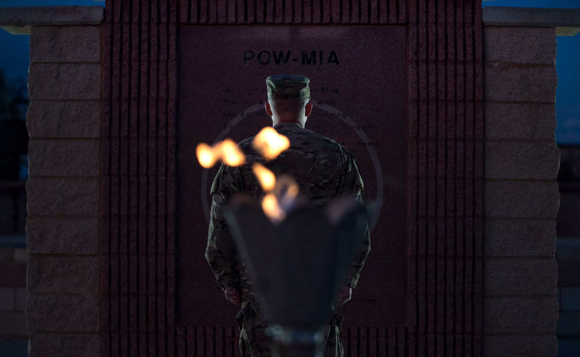 An Airman stands at attention in front of the POW/MIA Memorial at Heritage Park on Holloman Air Force Base, N.M., Sept. 20, 2019. During the 24-hour vigil, Airmen took turns standing at the memorial, honoring service members who were imprisoned and remain missing-in-action. (U.S. Air Force photo by Staff Sgt. Christine Groening)