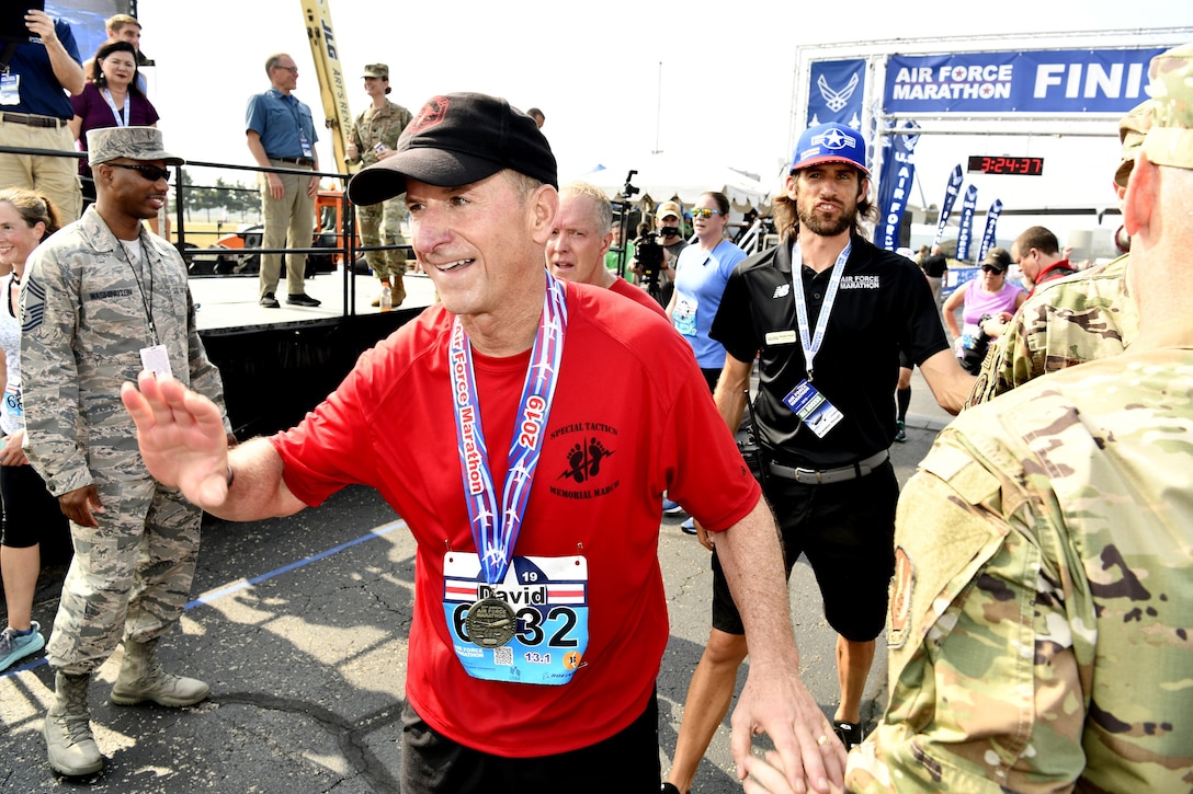 Air Force Chief of Staff Gen. David L. Goldfein acknowledges congratulations after finishing the Air Force Half Marathon Sept. 21, 2019 at Wright-Patterson AFB, Ohio. Goldfein’s shirt honored the Special Tactics Memorial March earlier this year that paid tribute to Staff Sgt. Dylan Elchin a Special Tactics combat controller who was killed in Afghanistan in 2018. His hat carried a SERE instructor logo that was given to him during a visit to Fairchild AFB. (U.S. Air Force photo by Scott Ash)