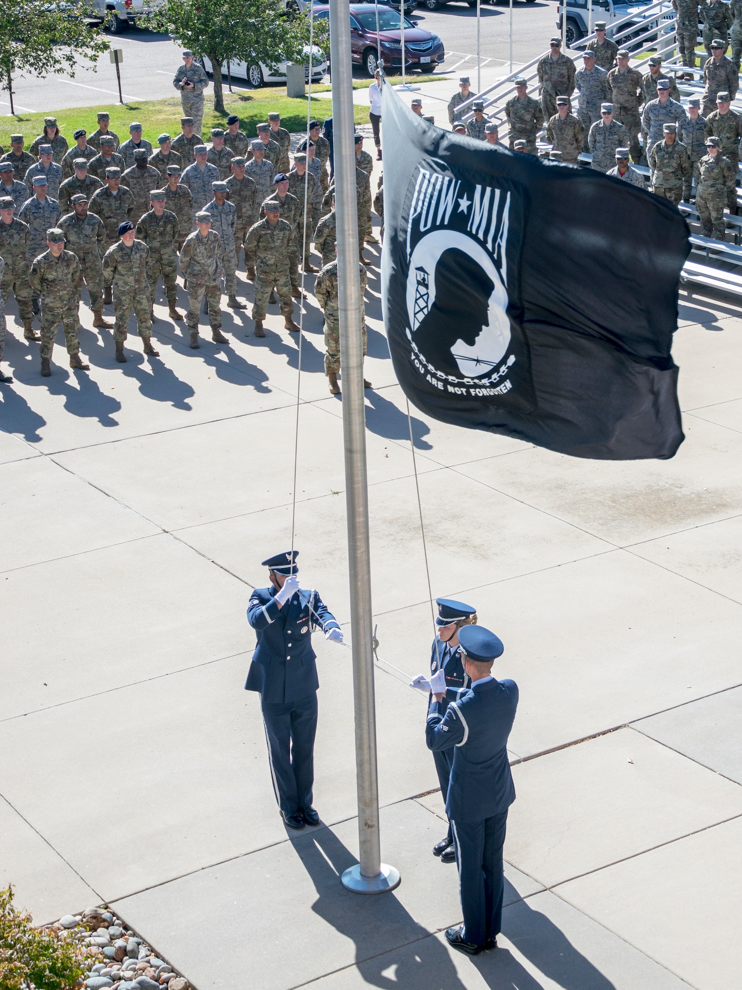 The High Frontier Honor Guard lowers the Prisoner of War/Missing in Action flag Sept. 20, 2019, at Peterson Air Force Base, Colorado, during a retreat ceremony at the end of POW/MIA Remembrance Week. Sept. 20 was National POW/MIA Recognition Day, started to honor veterans lost in the Vietnam War but since expanded to honor all former POWs and families of service members MIA in all U.S.-involved conflicts. (U.S. Air Force photo by Griffin Swartzell)