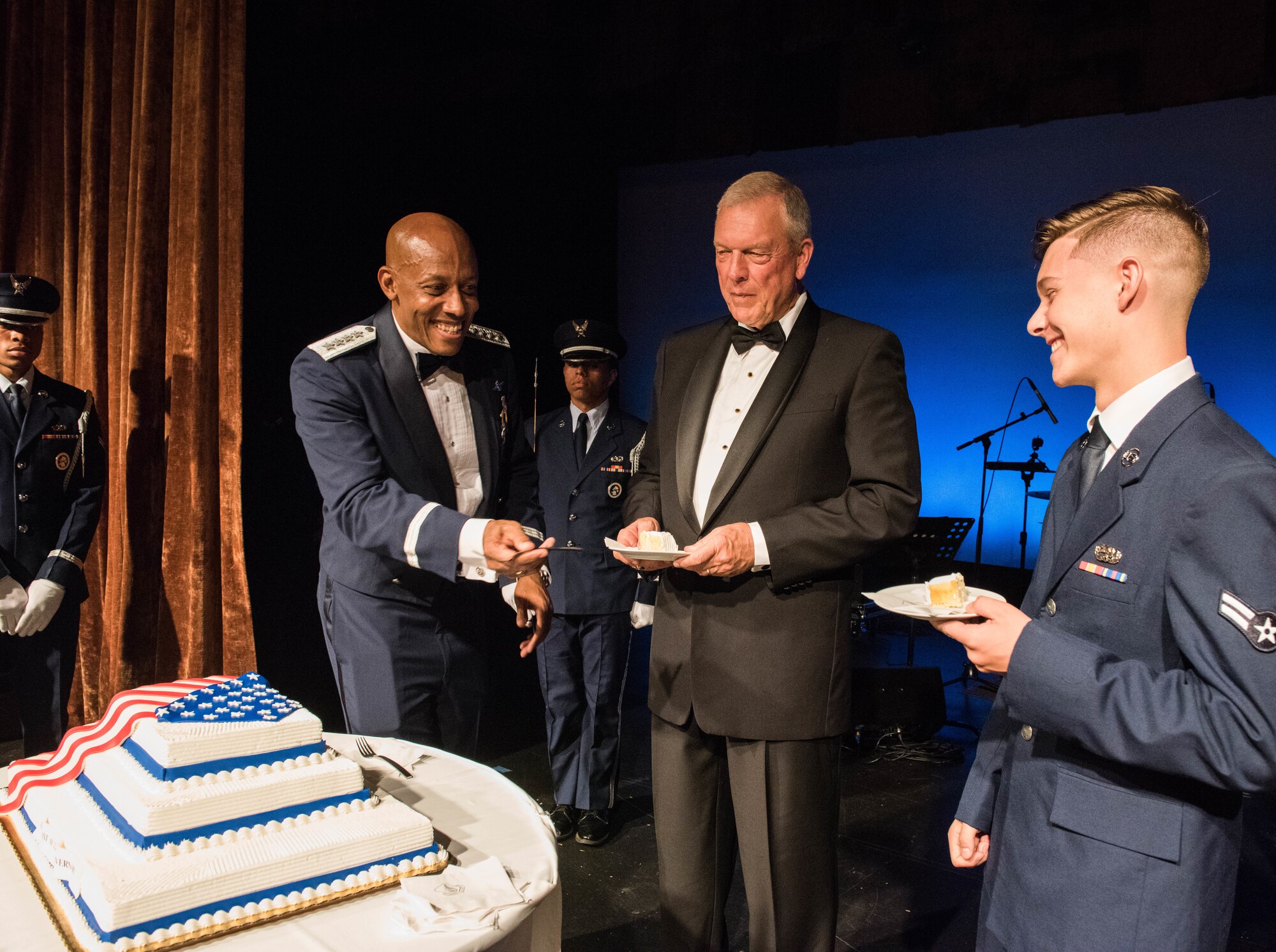 Gen. CQ Brown, Jr., Pacific Air Forces commander, hands a fork to Airman 1st Class Treye Plants, the most junior Air Force member in attendance of the Air Force ball, as Gen. (retired) Patrick Gamble, former PACAF commander, looks on, Honolulu, Hawaii, Sept. 20, 2019. This year, the United States Air Force celebrated its 72nd birthday and Pacific Air Forces celebrated its 75th anniversary. As part of the birthday and anniversary celebrations, six former PACAF commanders and command chiefs visited Hawaii and were guests of honor. (U.S. Air Force photo by Staff Sgt. Hailey Haux)