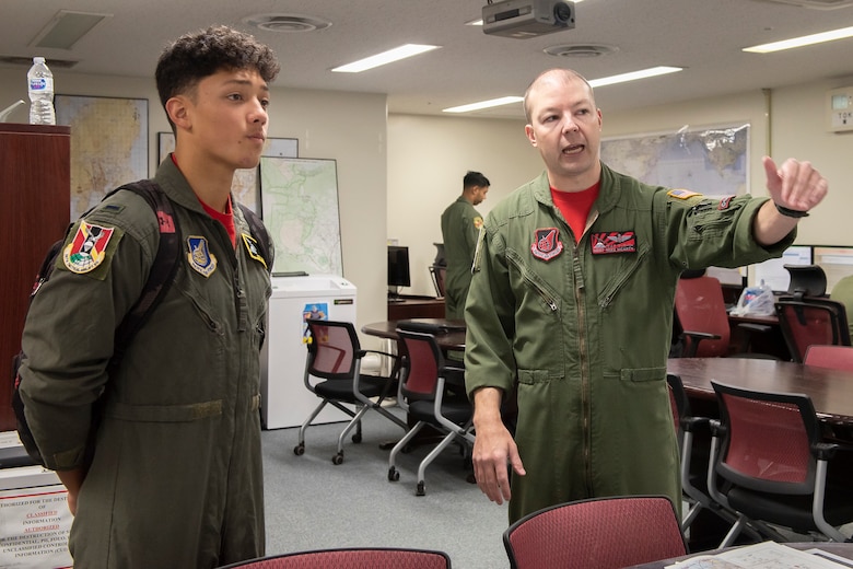 Joey DeGrella, Yokota High School senior and Junior Reserve Officer Training Corps. class commander, learns how each office contributes to the overall mission of the 36th Airlift Squadron from Master Sgt. Michael McArty, 36 AS C-130J Super Hercules instructor loadmaster, during the Pilot for a Day program, Sept. 20, 2019, at Yokota Air Base, Japan.