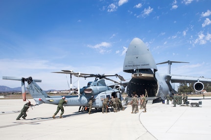U.S. Marines and airmen assist in loading a UH-1Y Venom into C-5M Super Galaxy at Marine Corps Air Station Camp Pendleton, California, Sept. 16. The C-5M was a visiting U.S. Air Force aircraft from 433rd Airlift Wing at Joint Base San Antonio-Lackland, Texas, and was here as part of a dual service training exercise. The air station provides the 1st Marine Expeditionary Force and 3rd Marine Aircraft Wing with flexible deployment options.