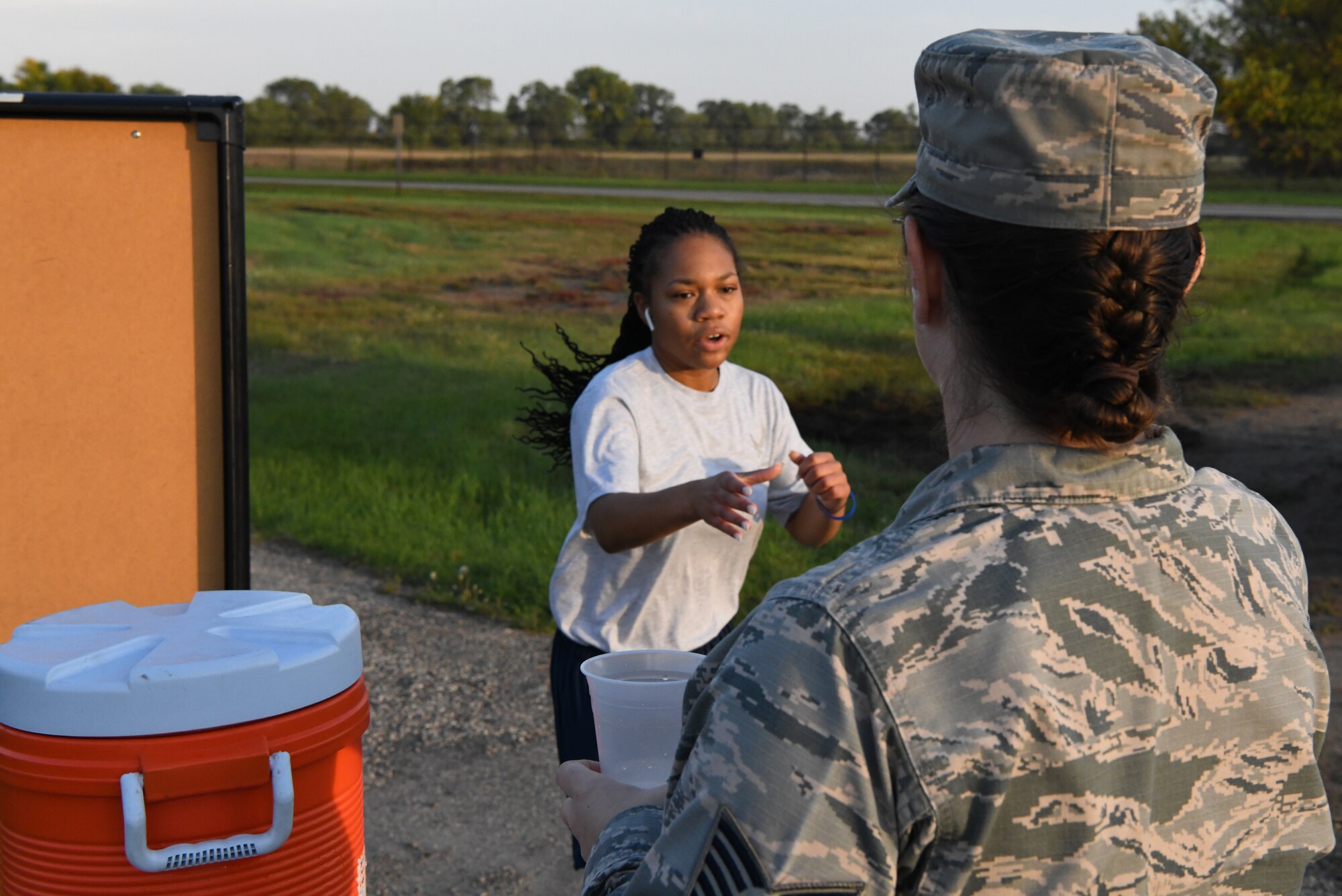 Senior Airman Dakaysiah Posey, 319th Logistics Readiness Squadron logistics planner, reaches for a cup of water from a wingman during a Suicide Awareness 5K Sept. 20, 2019, on Grand Forks Air Force Base, North Dakota. The 5K was a base community event that gave participants the opportunity to memorialize those who have struggled with or been lost to suicide. (U.S. Air Force photo by Airman 1st Class Brody Katka)