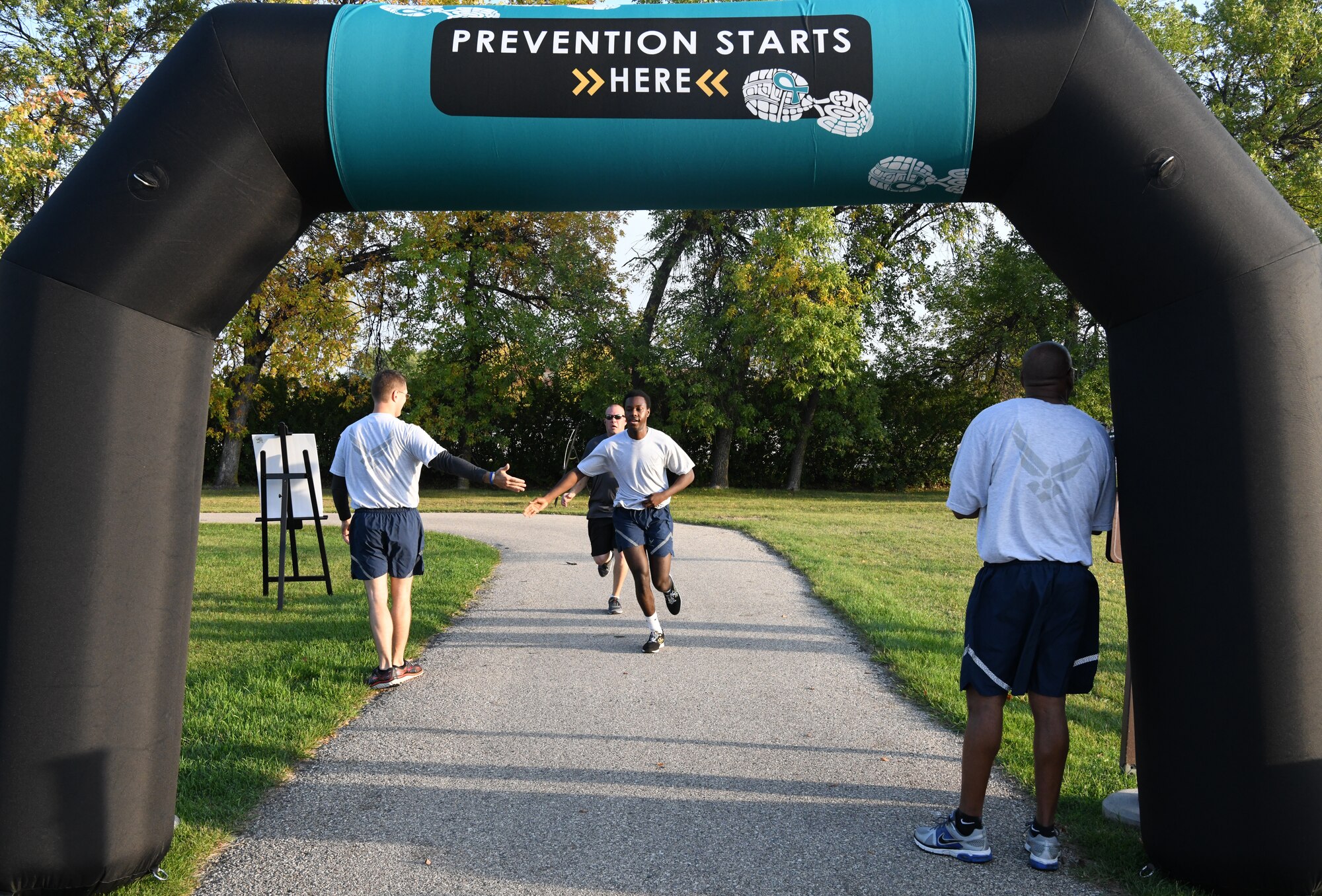 Airmen and family members from the 319th Reconnaissance Wing begin a Suicide Awareness 5K Sept. 20, 2019, on Grand Forks Air Force Base, North Dakota. Squadrons and flights were encouraged to attend the 5K in groups wearing their morale shirts and carrying unit guidons. (U.S. Air Force photo by Airman 1st Class Brody Katka)