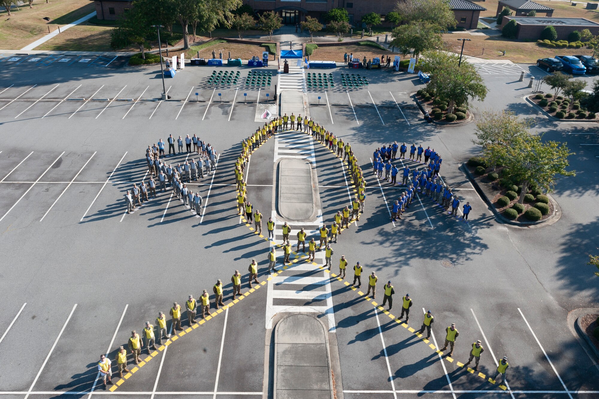 Moody Airmen form human ribbons during the Violence Prevention Awareness event Sept. 25, 2019, at Moody Air Force Base, Ga. The Violence Prevention Awareness event recognized and informed Airmen about suicide, domestic violence prevention and stalking awareness. (U.S. Air Force photo by Airman Elijah M. Dority)