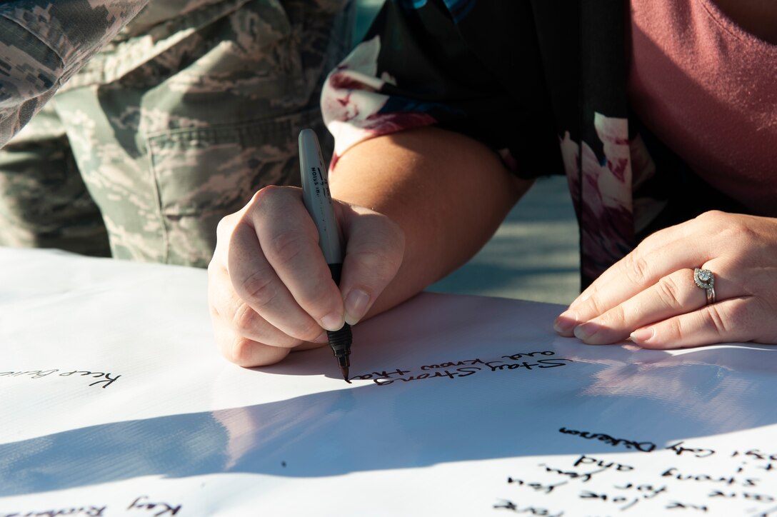 An attendee of the Violence Prevention Awareness event signs a poster Sept. 25, 2019, at Moody Air Force Base, Ga. The Violence Prevention Awareness event recognized and informed Airmen about suicide, domestic violence prevention and stalking awareness. (U.S. Air Force photo by Airman Elijah M. Dority)