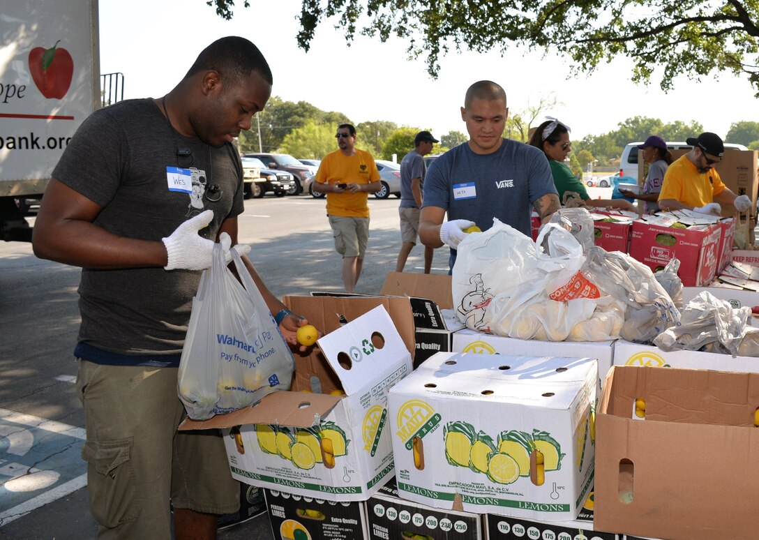 Staff Sgt. Salathiel Wesley, 433 Maintenance Squadron aerospace ground equipment technician, and Tech. Sgt. Mitt Mekpongsatorn, 433rd Maintenance Group aerospace ground equipment technician, assemble packages of fresh fruit during a San Antonio Food Bank distribution event at Windcrest United Methodist Church Sept. 19, 2019.