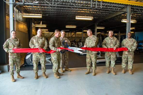Col. Joel Safranek, 436th Airlift Wing commander, cuts a ribbon during a ceremony unveiling the new maintenance squadron gym Sept. 10, 2019, at Dover Air Force Base, Del. The gym was assembled in two days and cost approximately $80,000. (U.S. Air Force photo by Senior Airman Christopher Quail)