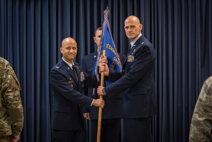 U.S. Air Force Col. Terrence Koudelka, left, the commander of the 193rd Special Operations Wing, Pennsylvania Air National Guard, passes a guidon to Lt. Col. Kristian Post, the commander of the 193rd Regional Support Group, during an assumption of command ceremony.