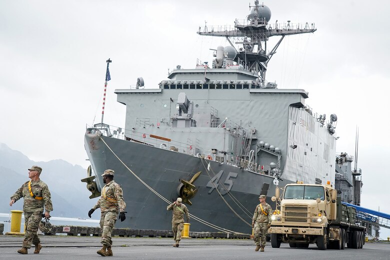 Soldiers assigned to the 109th Transportation Company, 17th Combat Support Sustainment Battalion, U.S. Army Alaska, lead an M915A5 tractor with an M872 trailer away from the port of Seward after loading U.S. Marine Corps bulk fuel supplies and equipment from the U.S.S. Comstock (LSD-45), a Whidbey Island-class dock landing ship, in Seward, Alaska, Sept. 19, 2019, for transport to Joint Base Elmendorf-Richardson, Alaska. The U.S. Navy is conducting an Arctic Expeditionary Capabilities Exercise to test its logistical effectiveness and joint-service interoperability while responding to conflict or disaster in an austere environment with no organic assets.