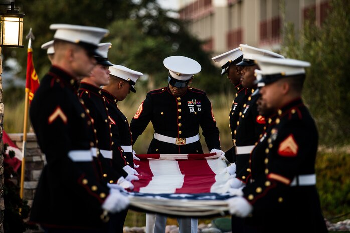 U.S. Marine Gunnery Sgt. Andre Adams, the quality assurance evaluator with Headquarters and Service Battalion, Headquarters and Support Battalion, Marine Corps Installations West, Marine Corps Base Camp Pendleton, folds the U.S. flag during the 77th Anniversary Evening Colors Ceremony at the Pacific Views Event Center on Camp Pendleton, California, Sept. 24, 2019. The ceremony was held in honor of the official dedication of MCB Camp Joseph H. Pendleton, which took place Sept. 25, 1942.