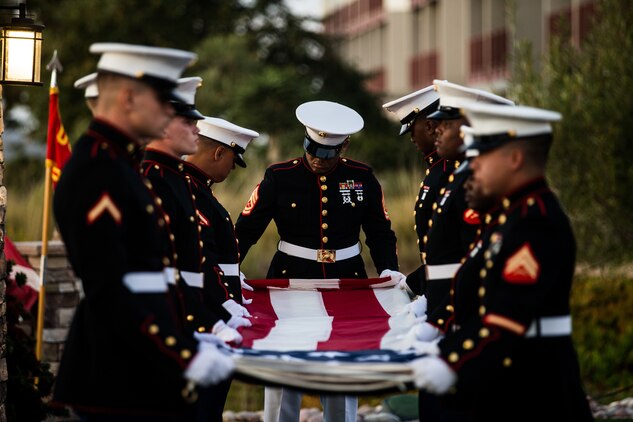 U.S. Marine Gunnery Sgt. Andre Adams, the quality assurance evaluator with Headquarters and Service Battalion, Headquarters and Support Battalion, Marine Corps Installations West, Marine Corps Base Camp Pendleton, folds the U.S. flag during the 77th Anniversary Evening Colors Ceremony at the Pacific Views Event Center on Camp Pendleton, California, Sept. 24, 2019. The ceremony was held in honor of the official dedication of MCB Camp Joseph H. Pendleton, which took place Sept. 25, 1942.