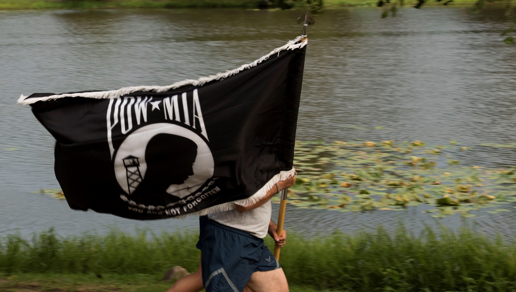 U.S. Air Force Airman runs with a prisoner of war/missing in action (POW/MIA) flag during a 24-hour run at Memorial Lake at Shaw Air Force Base, South Carolina, Sept. 18, 2019.