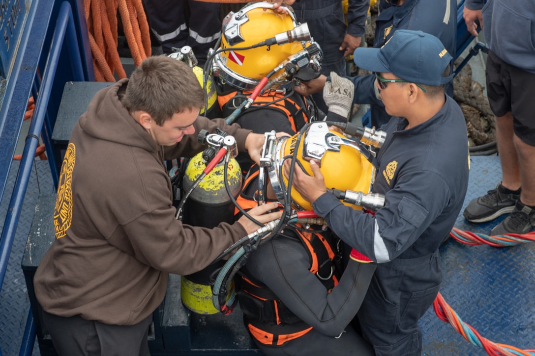 Peruvian navy divers don equipment prior.