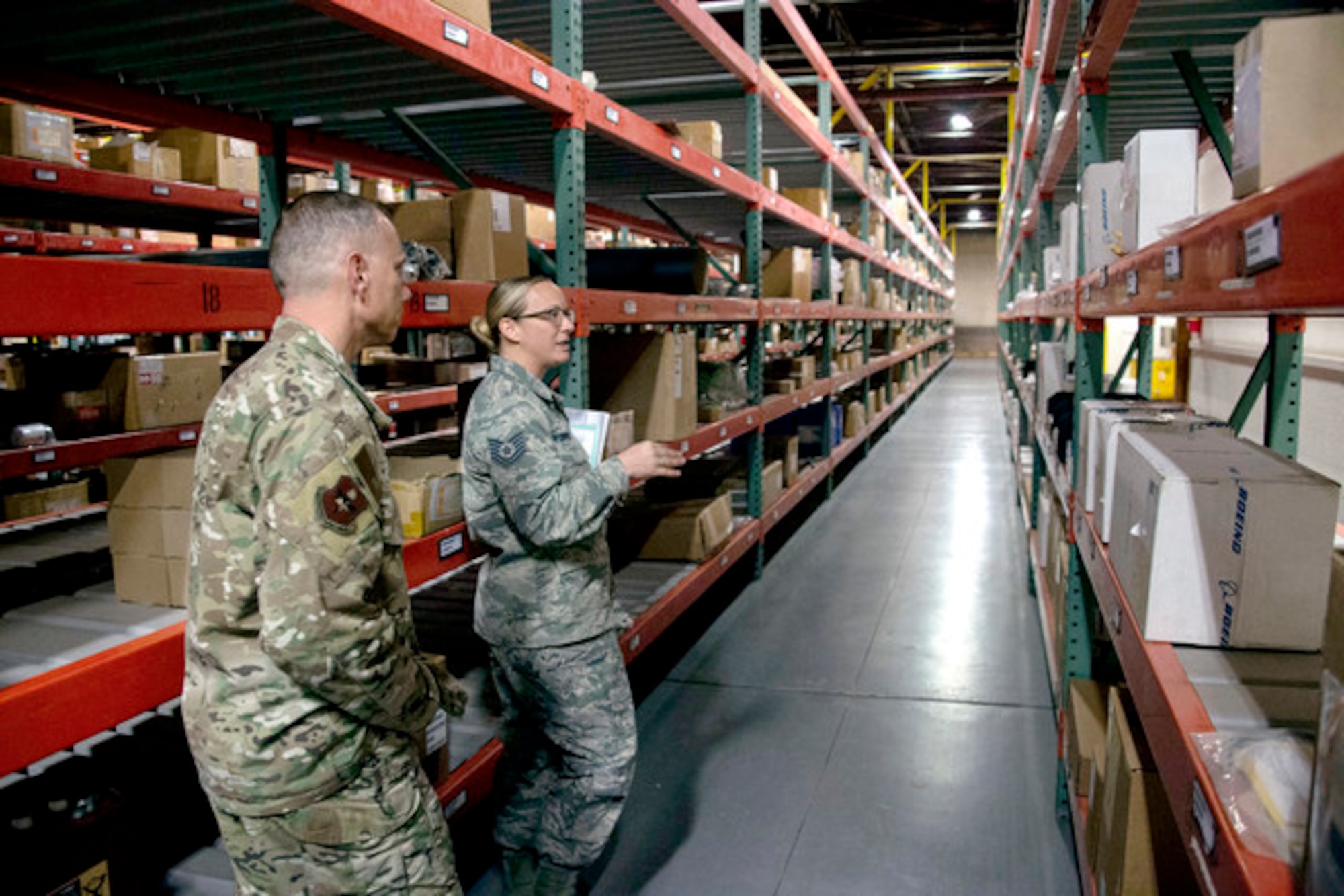 Tech Sgt. Nicole Finnegan, 97th Logistics Readiness Squadron noncommissioned officer in charge of storage, showcases the supply facility to Chief Master Sgt. Erik Thompson, 19th Air Force chief, in March at Altus Air Force Base, Okla. DLA’s Air Force NAM team helps Air Force logisticians obtain equipment and parts for various aircraft. (U.S. Air Force photo by Senior Airman Cody Dow)