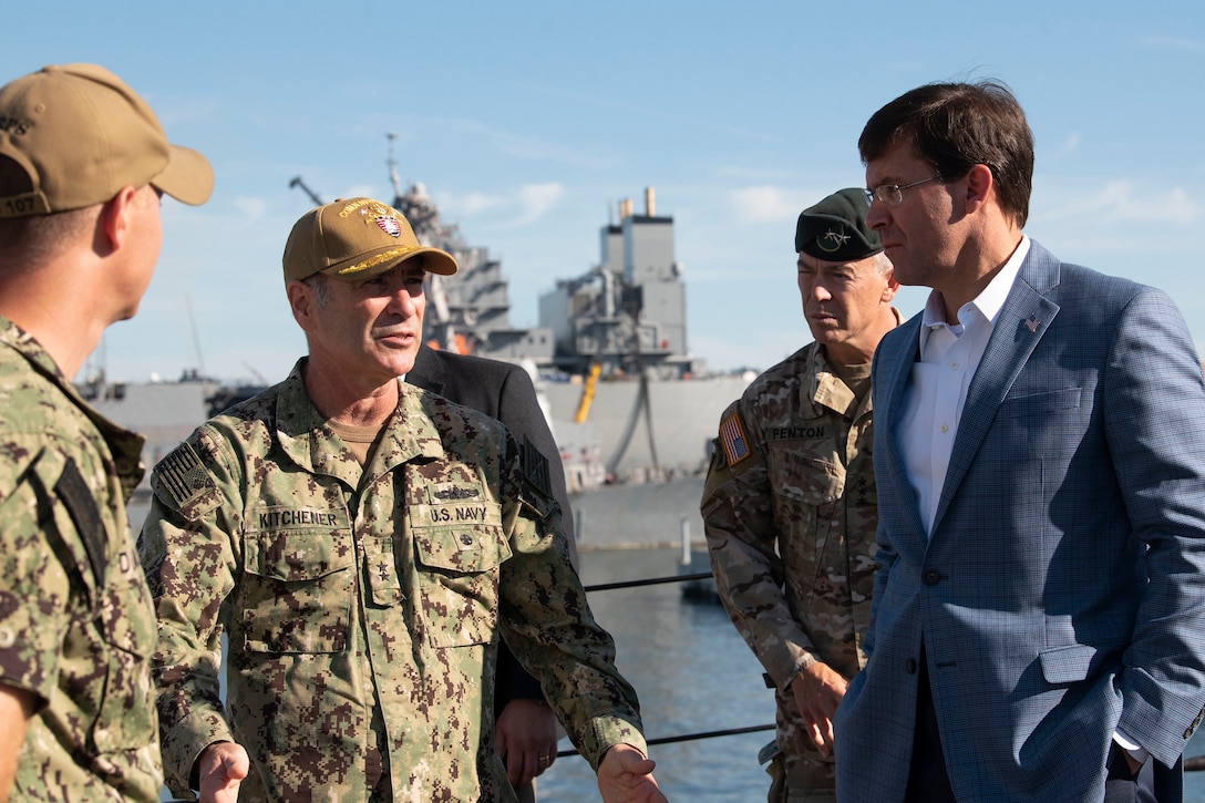 Defense Secretary Dr. Mark T. Esper speaks with a military officer.